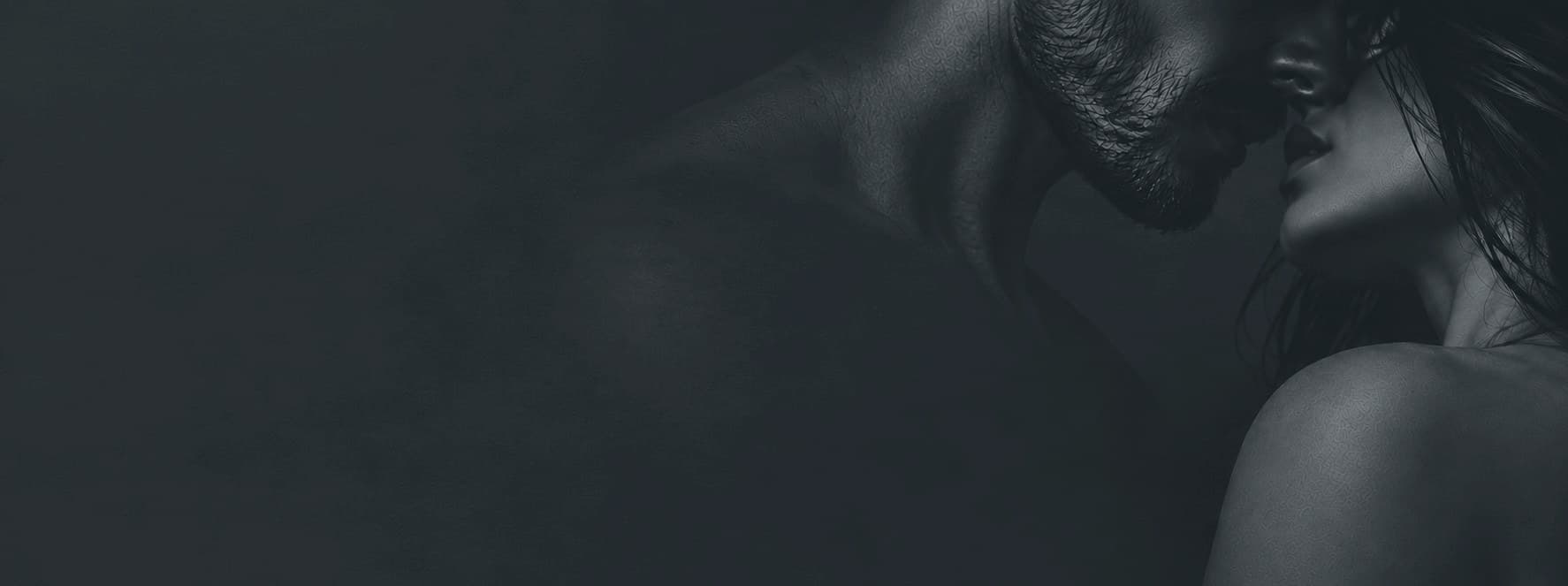 A couple in a close embrace, faces almost touching, in deep blue shadow
